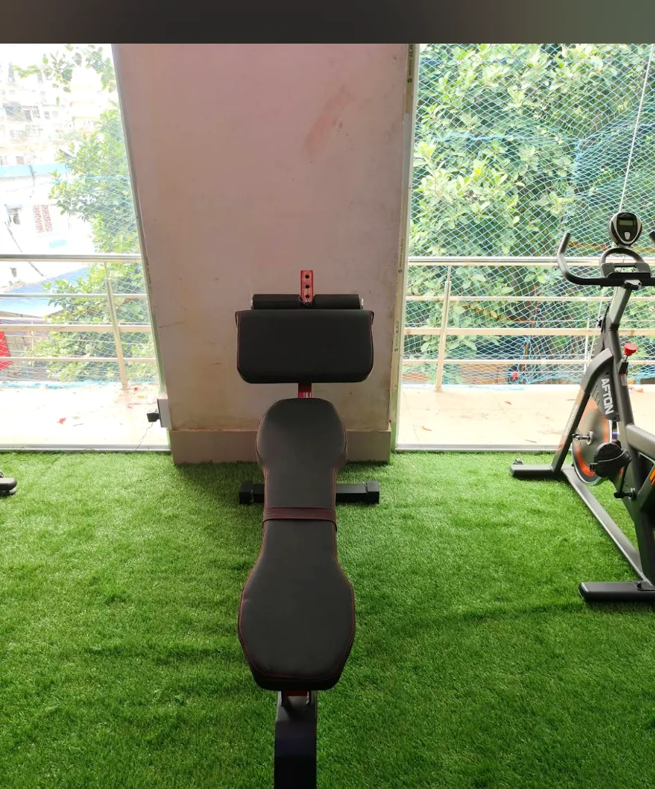 Adjustable workout bench and preacher curl station on green turf deck